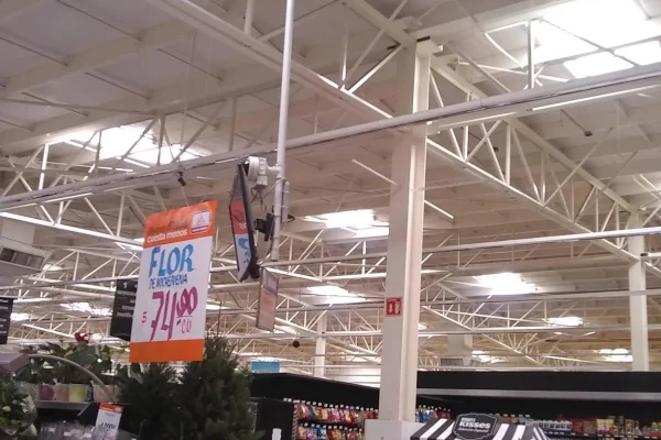 Techo plano y blanco de una nave industrial, con domos fijos y ventiladores en un día nublado, para iluminación y ventilación.